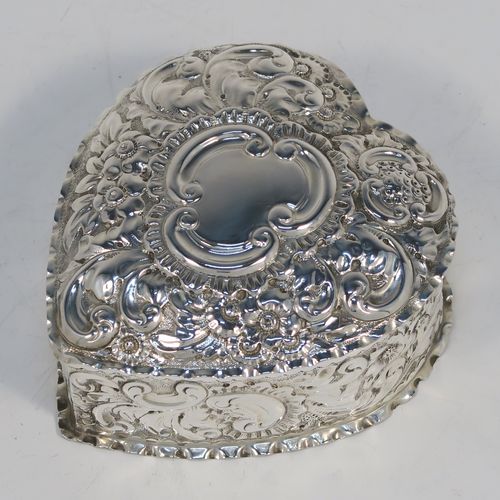 A very pretty Antique Victorian Sterling Silver heart-shaped table box, having a gold-gilt interior, all hand-chased with floral and scroll-work, a hinged lid with vacant cartouche, and all sitting on a flat base. This beautiful silver box was made by Deakin and Francis of Birmingham in 1893. The dimensions of this fine hand-made antique silver hear-shaped box are length 9 cms (3.5 inches), width 8 cms (3.25 inches), height 5 cms (2 inches), and it weighs approx. 96g (3 troy ounces).   