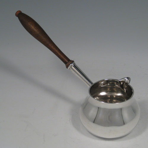    Antique Georgian sterling silver brandy sauce pan with wooden handle. Hallmarked for London in 1724. Length 23 cms (9