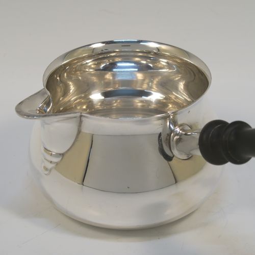 A handsome Antique Edwardian Sterling Silver brandy saucepan warmer, having a plain round bellied body, a sparrow-beak spout, an original wood turned handle, and sitting on a flat base. This elegant antique silver brandy or sauce warmer was made by William Abdy of London in ca. 1910 for the American market and is stamped with the Sterling word, and has been tested to 925 silver standard. The dimensions of this fine hand-made silver sauce or brandy warmer are height (inc. handle) 10 cms (4 inches), length (inc. handle) 19 cms (7.5 inches), diameter of main body 9 cms (3.5 inches), and it weighs approx. 200g (6.45 troy ounces).   