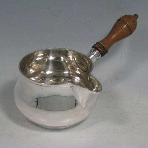 Antique Edwardian sterling silver brandy saucepan warmer, having a plain round baluster body, a sparrow-beak spout, an original wood turned handle, and sitting on a collet foot. Made in Birmingham in 1910. Height (inc. handle) 9 cms (3.5 inches), length (inc. handle) 18 cms (7 inches). Weight approx. 125g (4 troy ounces).