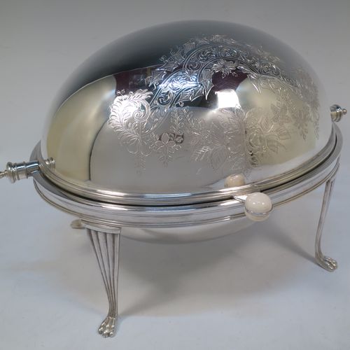 A very pretty Antique Victorian Silver Plated oval breakfast dish with revolving lid, and two original internal liners, having a hand-engraved body with floral and scroll decoration, an original bone insulated button, all sitting in a cast frame with fluted legs on lions-paw feet. Made by Mappin and Webb of Sheffield in ca. 1890. The dimensions of this fine hand-made antique silver-plated breakfast revolving serving dish are height 22 cms (8.5 inches), length 34 cms (13.5 inches), width 23 cms (9 inches).  