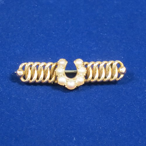 An Antique Victorian 15ct carat gold bar brooch, with the front having seven old pearls applied as a horse-shoe shape sitting on an inter-twined looped body, and the back having a plain steel security pin. Made in ca. 1880. The dimensions of this fine antique gold bar brooch are length 3.5 cms (1.3 inches), width 4 cms (1.5 inch), and it weighs approx. 4g. 