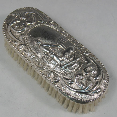 Antique Georgian sterling silver clothes brush made in London in 1773. A very rare piece chased with a pastoral scene. Length 15 cms.