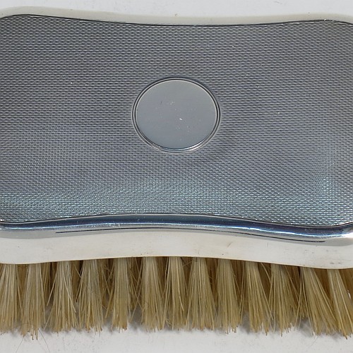 A very handsome Sterling Silver pair of gentle-mans hair brushes, having rectangular bodies with rounded corners, with engine-turned decoration and central vacant round cartouches, together with original pig bristles set into lacquered wooden bases. Made by Mappin and Webb of London in 1952. The dimensions of this fine pair of hand-made gentlemans hair brushes are length 12 cms (4.75 inches), and width 7 cms (2.75 inches).  