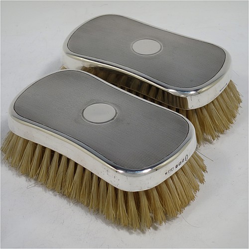 A very handsome Sterling Silver pair of gentle-mans hair brushes, having rectangular bodies with rounded corners, with engine-turned decoration and central vacant round cartouches, together with original pig bristles set into lacquered wooden bases. Made by Mappin and Webb of London in 1952. The dimensions of this fine pair of hand-made gentlemans hair brushes are length 12 cms (4.75 inches), and width 7 cms (2.75 inches).  