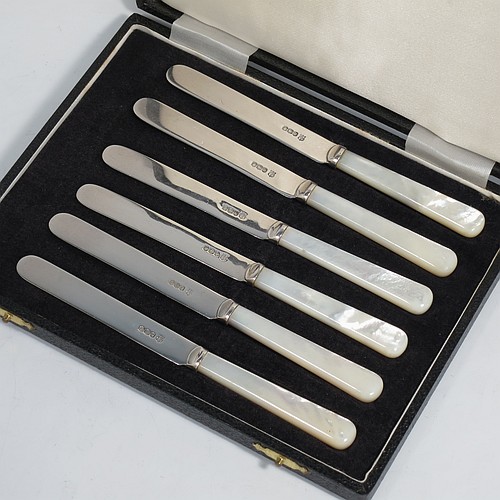 A Sterling Silver and Mother-of-Pearl handled set of six butter or tea knives, having plain mother-of-pearl handles, and plain silver parallel sided and rounded-end blades, all in their original cream satin and black velvet-lined presentation box. Made by Charles Boyton & Sons of Sheffield in 1966. The dimensions of this fine hand-made set of tea or butter knives are length of each knife 15 cms (6 inches).