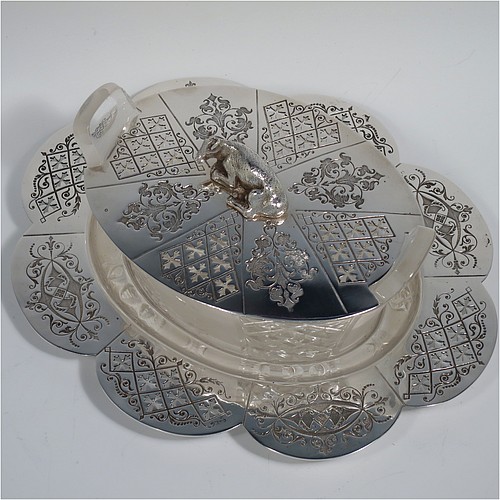 An Antique Victorian Silver Plated butter dish and cover, having an oval crystal body with panels of hand-cut and frosted decoration, a lift-off hand-engraved lid with a cast cow finial, and all sitting on a hand-engraved and pierced lobed oval dish. Made in ca. 1880. The dimensions of this fine hand-made antique silver plated butter dish are height 8 cms (3 inches), length 23 cms (9 inches), and width 19 cms (7.5 inches).    