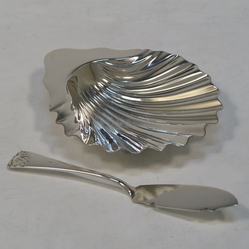 A very handsome Antique Victorian Sterling Silver butter shell dish and butter knife, having a hand-chased scalloped body, and sitting on three cast conch-shell feet. The butter shell made by Francis Higgins of London in 1885, and the butter knife made by Charles Boyton of London in 1887. The dimensions of this fine hand-made antique silver butter dish shell are length 12 cms (4.75 inches), width 10 cms (4 inches), and the total weight including knife is approx 98g (3.2 troy ounces).  