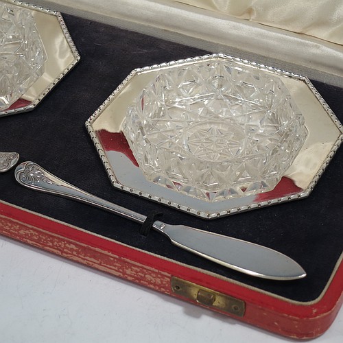 A very pretty Sterling Silver pair of Art Deco style butter dishes, having octagonal bodies with applied bead-edged borders, with removable hand-cut crystal dishes, and a pair of silver butter servers, all sitting in their original cream satin and black velvet-lined presentation box. Made by the Adie Brothers of Birmingham in 1936. The dimensions of this fine hand-made set of silver butter dishes and servers are width 11 cms (4.25 inches), height 2.5 cms (1 inch), with a total weight of approx. 145g (4.7 troy ounces).    