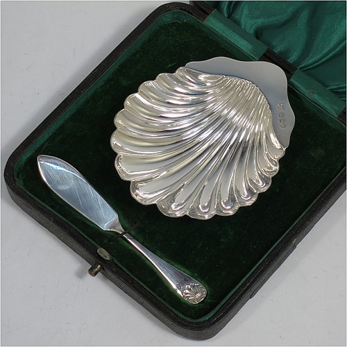 A very handsome Antique Victorian Sterling Silver butter shell and original butter knife, the shell having a hand-chased scalloped body, and sitting on three ball feet, the butter knife in the Old English Shell pattern, and all in their original green satin and velvet-lined presentation box. Made by John & William Deakin of Sheffield in 1898. The dimensions of this fine hand-made antique silver butter dish and knife are length of dish 10 cms (4 inches), width 8.5 cms (3.25 inches), length of knife 10.5 cms (4.25 inches), and they weigh a total of approx 51g (1.6 troy ounces).   