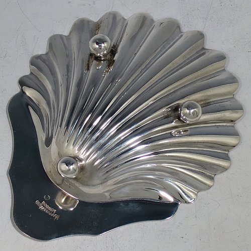 An Antique Victorian Sterling Silver pair of butter shells, having hand-chased scalloped bodies, plain shaped thumb-pieces, and both sitting on three ball feet. All made by Mappin & Webb of Sheffield in 1901. The dimensions of these fine hand-made antique silver butter dishes are length 12 cms (4.75 inches), width 9.5 cms (3.75 inches), height 2 cms (0.75 inches), and they have a total weight of approx. 146g (4.7 troy ounces).    