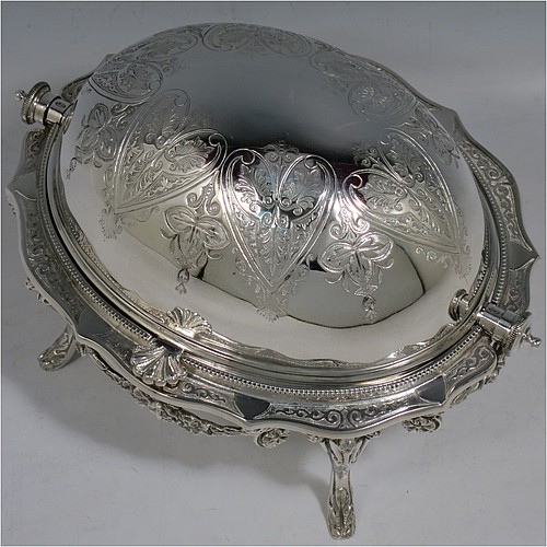 An Antique Victorian Silver Plated revolving top butter dish, having a hand-chased oval body with floral decoration and bead-edged border, a frosted glass removable internal liner, and sitting inside a cast frame with floral swags and four cast feet. All made in ca. 1880. The dimensions of this fine hand-made antique silver-plated butter dish are length 20 cms (8 inches), height 13 cms (5 inches), and width 15 cms (6 inches).    