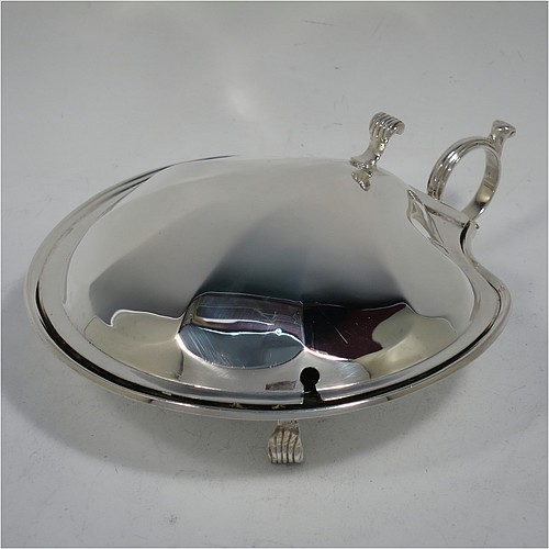 A very handsome and unusual Sterling Silver covered butter shell dish, having a hand-chased scalloped body, a hinged cover with a cast thumb-piece and knife slot, with a ring side-handle, a frosted cut removable liner, and all sitting on three cast reeded feet. Made by Henry Matthews of Birmingham in 1922. The dimensions of this fine hand-made silver butter dish shell are length 16.5 cms (6.5 inches), width 14 cms (5.5 inches), and it weighs approx 179g (5.7 troy ounces).    