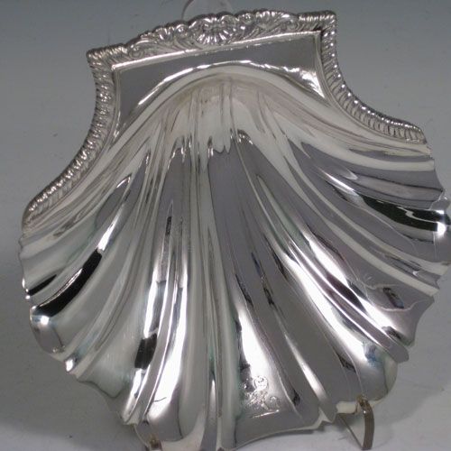    Antique Victorian sterling silver pair of butter shells, having a traditional scallop shape, cast shell and gadroon border, and sitting on two cast shell feet. One made by Robert Garrard of London in 1840 and the other made by William Cumming of London in 1856. Both are crested. Length 13 cms (5 inches), width 13.5 cms (5.25 inches). Total weight approx. 315g (10 troy ounces).