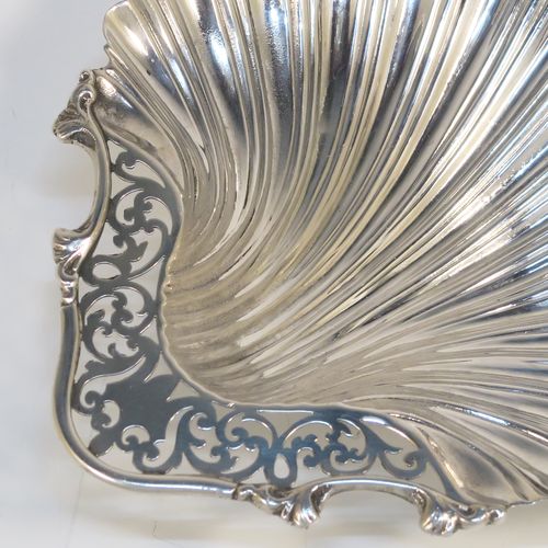 A very pretty Antique Edwardian Sterling Silver butter shell dish, having a hand-chased scalloped body, a hand-pierced handle with scroll-work and applied foliate border, and all sitting on three ball feet. This beautiful antique silver butter shell was made by Thomas Latham & Ernest Morton of Chester in 1902. The dimensions of this fine hand-made antique silver butter dish shell are length 14 cms (5.5 inches), width 12.5 cms (5 inches), and it weighs approx 75g (2.4 troy ounces).  