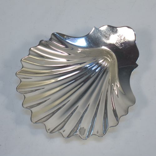 A very handsome Antique Georgian Sterling Silver butter shell, having a hand-chased traditional scallop shape, and sitting on three cast conch shell feet. Made by William Plummer of London in 1790. The dimensions of this fine hand-made antique silver butter shell are length 14.5 cms (5.75 inches), width 12 cms (4.75 inches), and with a weight of approx. 110g (3.5 troy ounces). Please note that this item is crested.  