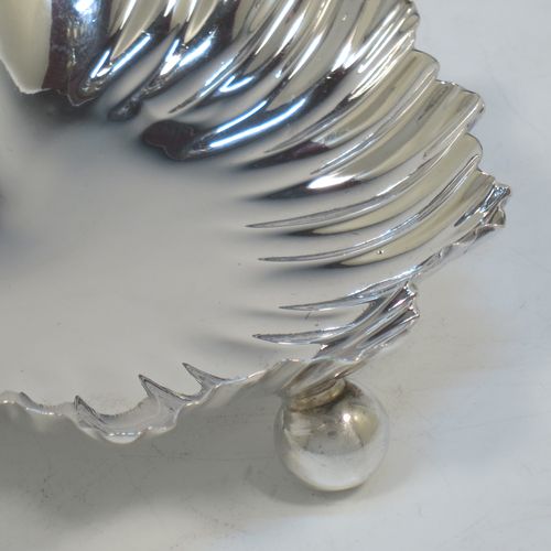 A very pretty pair of Antique Victorian Sterling Silver butter shells or dishes, having hand-chased scalloped bodies, plain shaped thumb-pieces, and both sitting on three ball feet. All made by Finlay and Taylor of Birmingham in 1889. The dimensions of these fine hand-made antique silver butter dishes or shells are length 12 cms (4.75 inches), width 11 cms (4.3 inches), height 3 cms (1.25 inches), and they have a total weight of approx. 135g (4.3 troy ounces).   