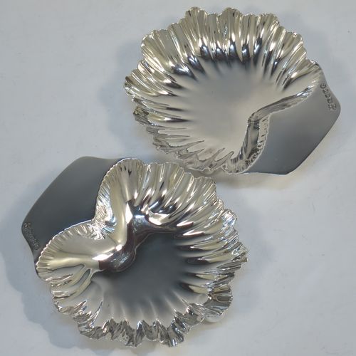 A very pretty pair of Antique Victorian Sterling Silver butter shells or dishes, having hand-chased scalloped bodies, plain shaped thumb-pieces, and both sitting on three ball feet. All made by Finlay and Taylor of Birmingham in 1889. The dimensions of these fine hand-made antique silver butter dishes or shells are length 12 cms (4.75 inches), width 11 cms (4.3 inches), height 3 cms (1.25 inches), and they have a total weight of approx. 135g (4.3 troy ounces).   