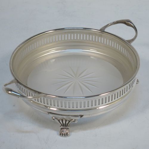 A very handsome Sterling Silver pair of neoclassical  style butter dishes, having round bodies with applied reeded borders and hand-pierced gallery sides, with two cast side handles and original removable hand-cut crystal dishes with star-cut bases, all sitting on three cast and fluted flange feet, together with a pair of silver butter knives in the Albany pattern. All sitting in their original cream satin and black velvet-lined presentation box. The butter dishes made by Henry Moreton of Birmingham in 1924, and the butter knives by Gibson and Langman of London in 1896. The dimensions of this fine hand-made set of silver butter dishes are diameter 11 cms (4.25 inches), height 4 cms (1.5 inches), length of butter knives 14 cms (5.5 inches), with a total weight of approx. 186g (6 troy ounces). Please note that the satin hinges to the box are damaged. 