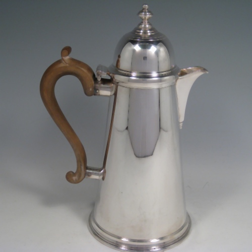 Silver-plated pair of cafe-au-lait serving pots in the George I style with domed hinged lids, straight sided, and wooden handles. Made by Aspreys of London in ca. 1950. Height 25.5 cms (10 inches), length of coffee pot 19 cms (7.5 inches).