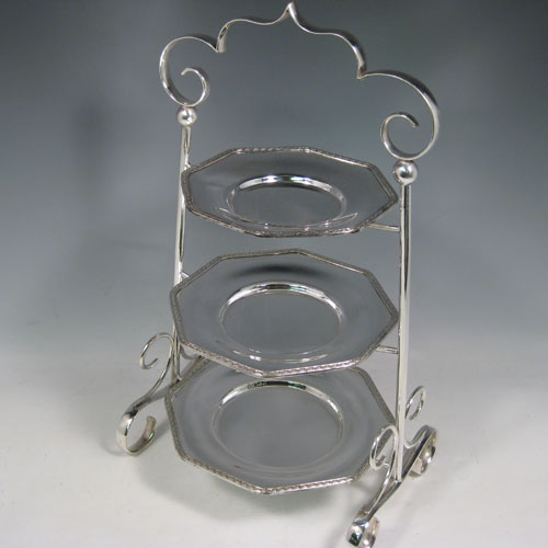 Antique Edwardian silver plated three-tier cake stand, having a graduated suite of three removable octagonal plates with applied leaf borders, sitting within a very pretty tapering frame with scroll-work handle and feet. Made by Frederick Atkins of Sheffield in ca. 1910. The dimensions of this fine hand-made silver-plated cake stand are height 38 cms (15 inches), width at base 22 cms (8.6 inches), width of largest plate 18 cms (7 inches), width of smallest plate 14 cms (5.5 inches).   