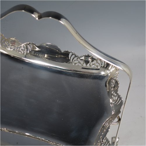 An Antique Edwardian pretty silver-plated cake stand, having two rectangular plates with hand-pierced floral borders, all held in a plain wire-work frame sat on four flanged feet. All made by Thomas Wilkinson of Sheffield in ca. 1900. The dimensions of this fine hand-made silver-plated cake stand are height 32 cms (12.5 inches), length 25.5 cms (10 inches), and width 16 cms (6.5 inchs).   