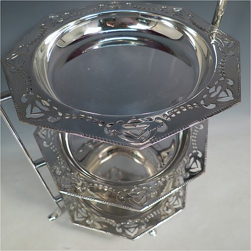 An Antique Edwardian very pretty silver-plated cake stand, having three removable octagonal dishes with hand-pierced borders showing pairs of Swallows, all held in a plain wire-work frame with a carrying handle and four scroll feet. All made in ca. 1900. The dimensions of this fine hand-made antique silver-plated cake stand are height 43 cms (17inches), width 30.5 cms (12 inchs), and the diameter of the inside of the dishes is 18 cms (7 inches).   