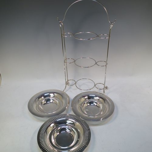 A pretty Antique Edwardian Silver Plated three-tier cake stand, having a suite of three removable round plates with pierced borders and fairly deep bowls, sitting within a very pretty wire-work frame with scroll-work handle and four ball feet. Made in ca. 1900. The dimensions of this fine hand-made antique silver-plated cake stand are height 49 cms (19.25 inches), width across feet at base 26 cms (10.25 inches), and diameter of plates are 21 cms (8.25 inches).  