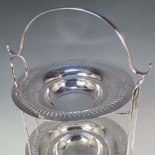 A pretty Antique Edwardian Silver Plated three-tier cake stand, having a suite of three removable round plates with pierced borders and fairly deep bowls, sitting within a very pretty wire-work frame with scroll-work handle and four ball feet. Made in ca. 1900. The dimensions of this fine hand-made antique silver-plated cake stand are height 49 cms (19.25 inches), width across feet at base 26 cms (10.25 inches), and diameter of plates are 21 cms (8.25 inches).  