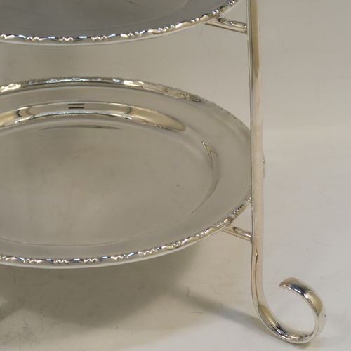 A very pretty Antique Edwardian silver plated three-tier cake stand, having a graduated suite of three removable round plates with applied egg and dart, sitting within a very handsome tapering frame with scroll-work handle and feet. This beautiful antique silver-plated three-tier cake stand was made in ca. 1910. The dimensions of this fine hand-made silver-plated cake stand are height 42 cms (16.5 inches), width at base 30.5 cms (12 inches), diameter of largest plate 20 cms (8 inches), and of of smallest plate 16 cms (6.3 inches).   