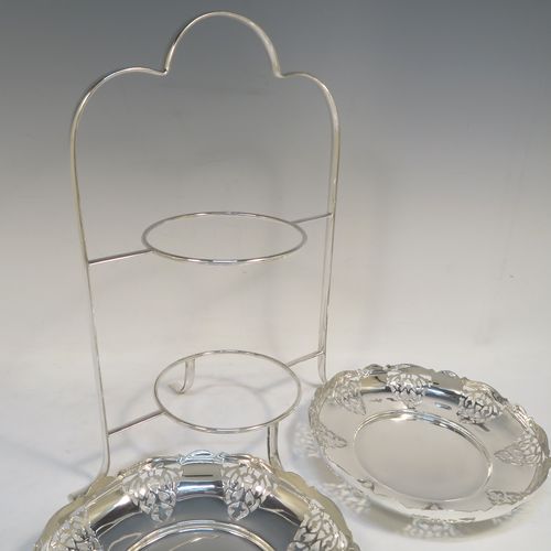 A pretty Antique Edwardian silver-plated cake stand, having two removable scalloped plates with round bodies and hand-pierced floral decoration. All sitting in a plain wire-work frame which in-turn sits on four scroll feet. This beautiful antique silver-plated cake stand was made in Sheffield ca. 1910. The dimensions of this fine hand-made antique silver-plated cake stand are height 36 cms (14.25 inches), width 30 cms (11.75 inches), and the plates are 21 cms (8.25 inches) square.   