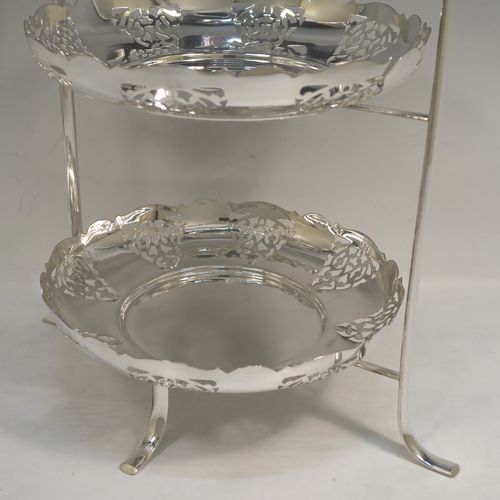 A pretty Antique Edwardian silver-plated cake stand, having two removable scalloped plates with round bodies and hand-pierced floral decoration. All sitting in a plain wire-work frame which in-turn sits on four scroll feet. This beautiful antique silver-plated cake stand was made in Sheffield ca. 1910. The dimensions of this fine hand-made antique silver-plated cake stand are height 36 cms (14.25 inches), width 30 cms (11.75 inches), and the plates are 21 cms (8.25 inches) square.   