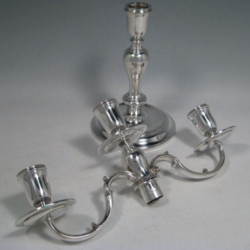 Sterling silver pair of three-light candelabra, having plain round baluster bodies, removable scroll arms, and with drip pans below the nozzles. Made by C. J. Vander of London in 1971. Height 30 cms (11.75 inches), spread across arms 30.5 cms (12 inches). Total weight approx. 1,583g (51 troy ounces). Please note that these candelabra are not filled.