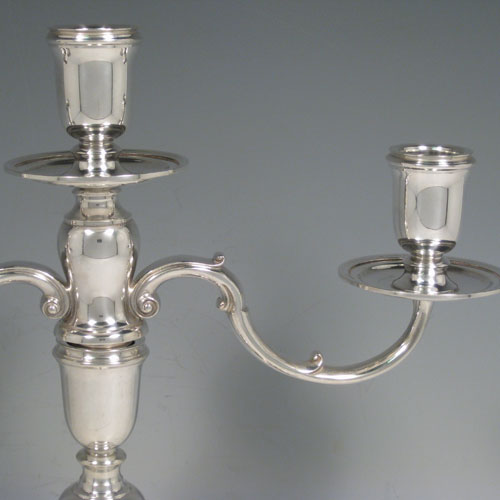 Sterling silver pair of three-light candelabra, having plain round baluster bodies, removable scroll arms, and with drip pans below the nozzles. Made by C. J. Vander of London in 1971. Height 30 cms (11.75 inches), spread across arms 30.5 cms (12 inches). Total weight approx. 1,583g (51 troy ounces). Please note that these candelabra are not filled.