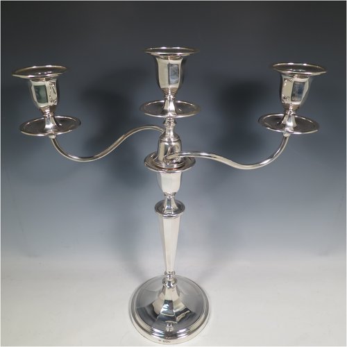 An Antique Edwardian Sterling Silver pair of candelabra in a round plain panelled style, having removable arms with three lights, panelled columns with round bases, double swirl panelled arms, capitals with removable nozzles and drip pans, and reed-edged borders. Made by Goldsmiths & Silversmiths of London in 1905. The dimensions of this fine hand-made pair of silver candelabra are height 44.5 cms (17.5 inches), and spread across arms 39.5 cms (15.5 inches).   