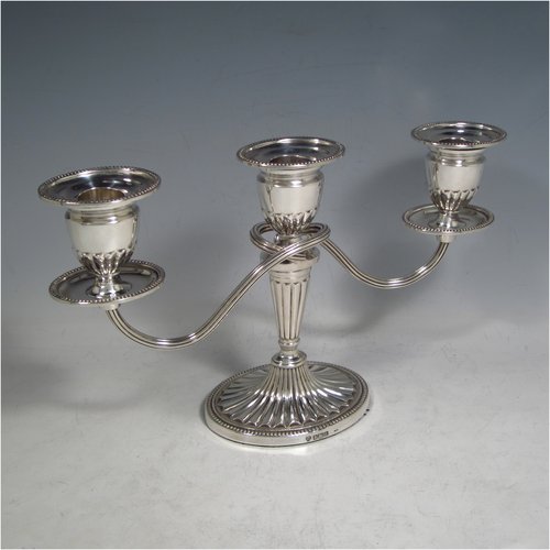 Sterling silver pair of small Neoclassical style three-light candelabra, having oval baluster bodies with fluted decoration and bead-edged borders, fixed arms with drip pans, and removable nozzles. Made by C. J. Vander of Sheffield in 1989. The dimensions of this fine hand-made pair of silver candelabra are height 16 cms (6.3 inches), and spread across arms 27.5 cms (10.75 inches).   