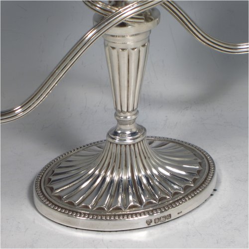 Sterling silver pair of small Neoclassical style three-light candelabra, having oval baluster bodies with fluted decoration and bead-edged borders, fixed arms with drip pans, and removable nozzles. Made by C. J. Vander of Sheffield in 1989. The dimensions of this fine hand-made pair of silver candelabra are height 16 cms (6.3 inches), and spread across arms 27.5 cms (10.75 inches).   