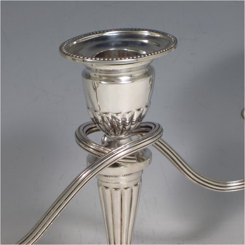 Sterling silver pair of small Neoclassical style three-light candelabra, having oval baluster bodies with fluted decoration and bead-edged borders, fixed arms with drip pans, and removable nozzles. Made by C. J. Vander of Sheffield in 1989. The dimensions of this fine hand-made pair of silver candelabra are height 16 cms (6.3 inches), and spread across arms 27.5 cms (10.75 inches).   