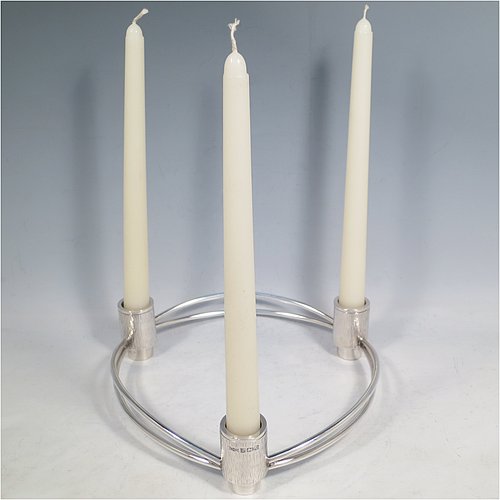 A Sterling Silver pair of very unusual Modernistic three-light candelabra, in a round style with bark-finish holders and removable nozzles, joined together with double wire-work sections. Made by Beatrice Midgley of Birmingham in 1973. The dimensions of this fine hand-made pair of silver candelabra are diameter 20 cms (8 inches), height 5 cms (2 inches), and with a total weight of approx. 840g (27 troy ounces).    