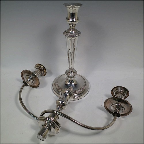 An Antique Georgian Old Sheffield Silver Plated pair of candelabra in a very elegant Regency style, having removable arms with three lights, with plain round baluster columns and bases, and plain reeded double swirl arms, removable nozzles with drip pans, and gadroon edged borders. Made in ca. 1810. The dimensions of this fine hand-made pair of Old Sheffield three-light candelabra are height 51 cms (20 inches), and spread across arms 40 cms (15.75 inches). Please note that these can be combined into a single five-light candelabrum if required.   