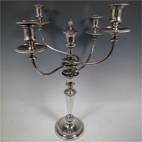 An Antique Georgian Old Sheffield Silver Plated pair of candelabra in a very elegant Regency style, having removable arms with three lights, with plain round baluster columns and bases, and plain reeded double swirl arms, removable nozzles with drip pans, and gadroon edged borders. Made in ca. 1810. The dimensions of this fine hand-made pair of Old Sheffield three-light candelabra are height 51 cms (20 inches), and spread across arms 40 cms (15.75 inches). Please note that these can be combined into a single five-light candelabrum if required.   