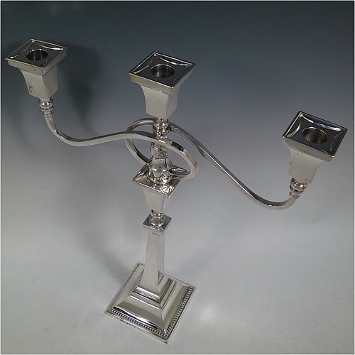 A very handsome Sterling Silver single Art Deco style candelabrum, having a square stepped base with an applied lower bead border, a plain panelled column with tapering sides, with double swirl reeded arms and matching capitals with removable nozzles. Made by Britton Gould and Co., of Birmingham in 1935. The dimensions of this fine hand-made silver Art Deco single candelabrum are height 41 cms (16.25 inches), spread across arms 33.5 cms (13.25 inches), and it weighs approx. 957g (31 troy ounces). Please note that this candelabrum is not filled, so the whole weight is silver.   