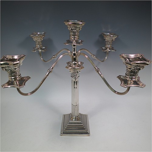 A Sterling Silver pair of large five-light Corinthian style candelabra, having fluted columns, acanthus-leaf capitals, stepped bases, bead-edge borders, and removable arms with drip pans and nozzles. Made by Britton Gould & Co., of Birmingham in 1930. The dimensions of this fine hand-made pair of candelabra are height 46 cms (18 inches), and spread across arms 51 cms (20 inches).