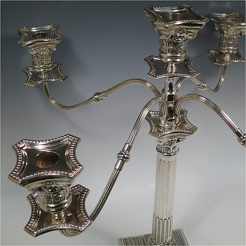 A Sterling Silver pair of large five-light Corinthian style candelabra, having fluted columns, acanthus-leaf capitals, stepped bases, bead-edge borders, and removable arms with drip pans and nozzles. Made by Britton Gould & Co., of Birmingham in 1930. The dimensions of this fine hand-made pair of candelabra are height 46 cms (18 inches), and spread across arms 51 cms (20 inches).