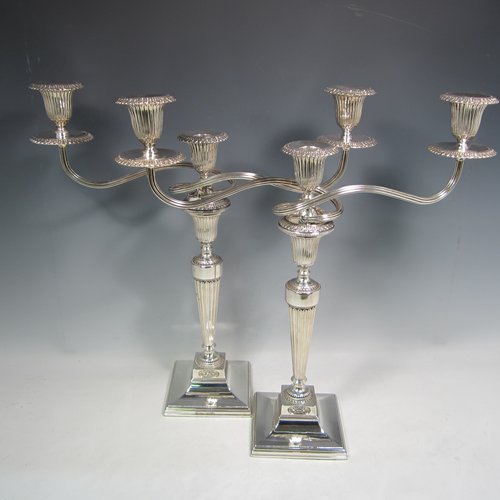 An Antique Georgian and 20th Century sterling silver pair of three-light candelabra with removable reed-work arms, hand-chased fluted decoration, square cross-section columns and bases, and applied Anthemion leaf borders. Please note that the candelabra bases are Georgian and made by Tudor & Leader of Sheffield in 1782, and the matching candelabra branches are made in London in 1956. The dimensions of this fine pair of hand-made silver candelabra are height 44 cms (17.25 inches), and spread across branches 43 cms (17 inches).   