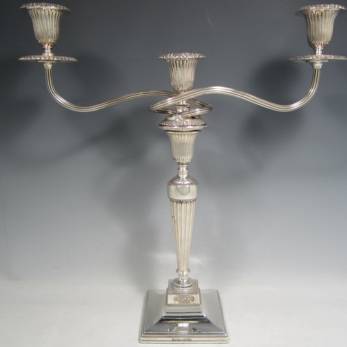 An Antique Georgian and 20th Century sterling silver pair of three-light candelabra with removable reed-work arms, hand-chased fluted decoration, square cross-section columns and bases, and applied Anthemion leaf borders. Please note that the candelabra bases are Georgian and made by Tudor & Leader of Sheffield in 1782, and the matching candelabra branches are made in London in 1956. The dimensions of this fine pair of hand-made silver candelabra are height 44 cms (17.25 inches), and spread across branches 43 cms (17 inches).   