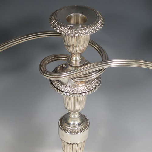 An Antique Georgian and 20th Century sterling silver pair of three-light candelabra with removable reed-work arms, hand-chased fluted decoration, square cross-section columns and bases, and applied Anthemion leaf borders. Please note that the candelabra bases are Georgian and made by Tudor & Leader of Sheffield in 1782, and the matching candelabra branches are made in London in 1956. The dimensions of this fine pair of hand-made silver candelabra are height 44 cms (17.25 inches), and spread across branches 43 cms (17 inches).   