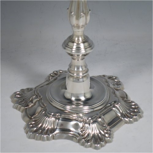 A Sterling Silver cast pair of George II style three-light candelabra, having round baluster bodies with six-shell borders, removable scroll arms with nozzles, and a central finial. Made by Mappin & Webb of Birmingham in 1969. The dimensions of this fine hand-made pair of silver candelabra are height 30 cms (11.75 inches), spread across arms 25 cms (9.75 inches), and with a total weight of approx. 2,538g (82 troy ounces). Please note that these candelabra are all cast and not filled.