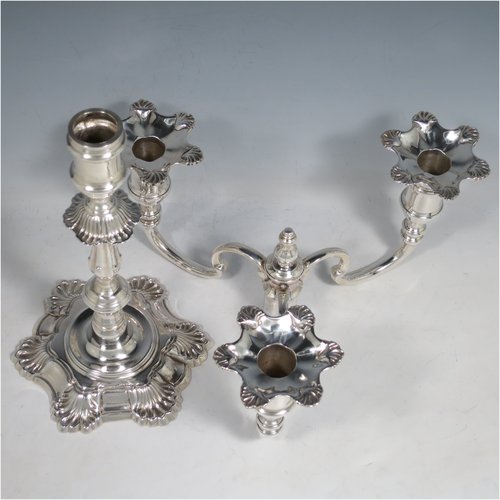 A Sterling Silver cast pair of George II style three-light candelabra, having round baluster bodies with six-shell borders, removable scroll arms with nozzles, and a central finial. Made by Mappin & Webb of Birmingham in 1969. The dimensions of this fine hand-made pair of silver candelabra are height 30 cms (11.75 inches), spread across arms 25 cms (9.75 inches), and with a total weight of approx. 2,538g (82 troy ounces). Please note that these candelabra are all cast and not filled.