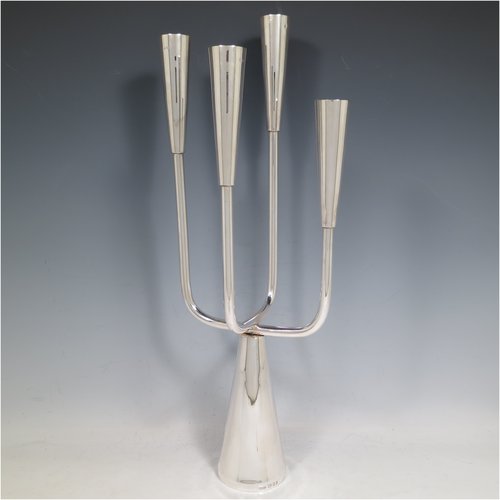 A Sterling Silver single candelabrum, in a  very plain Modernistic style, having four branched lights with tapering nozzles, all sitting on a cone-shaped base. The base, arms, and nozzles all screw together for ease of cleaning and storage. Made by A. Taite & Sons of London in 1970. The dimensions of this fine hand-made silver single candelabrum are height 43 cms (17 inches), and spread across arms 17 cms (6.75 inches).    